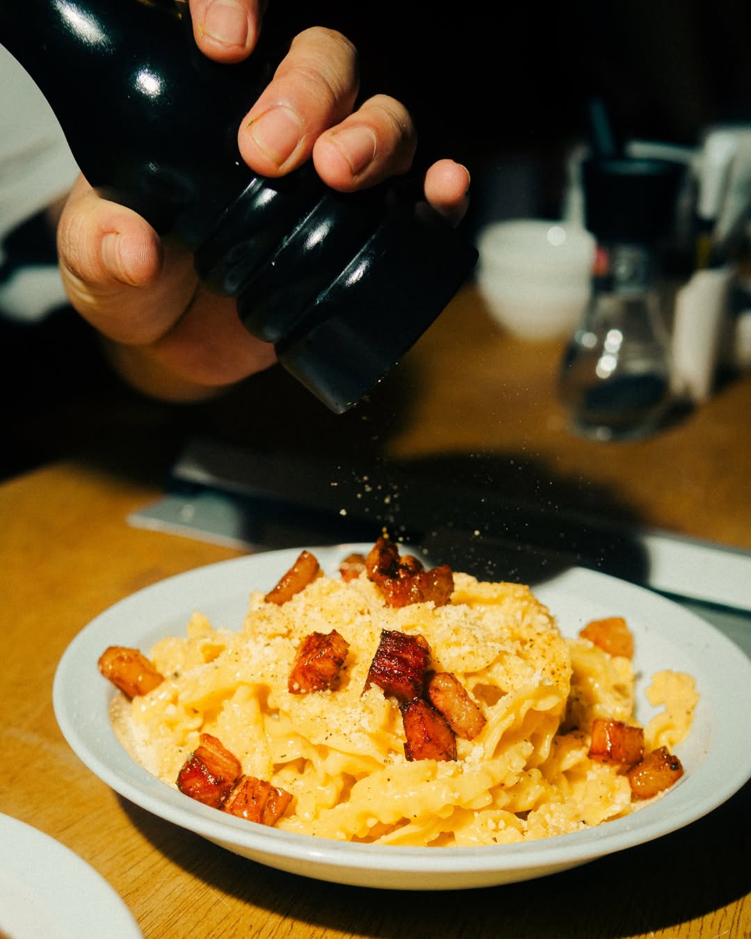 Massa com tomate-cereja e molho, servida num prato branco