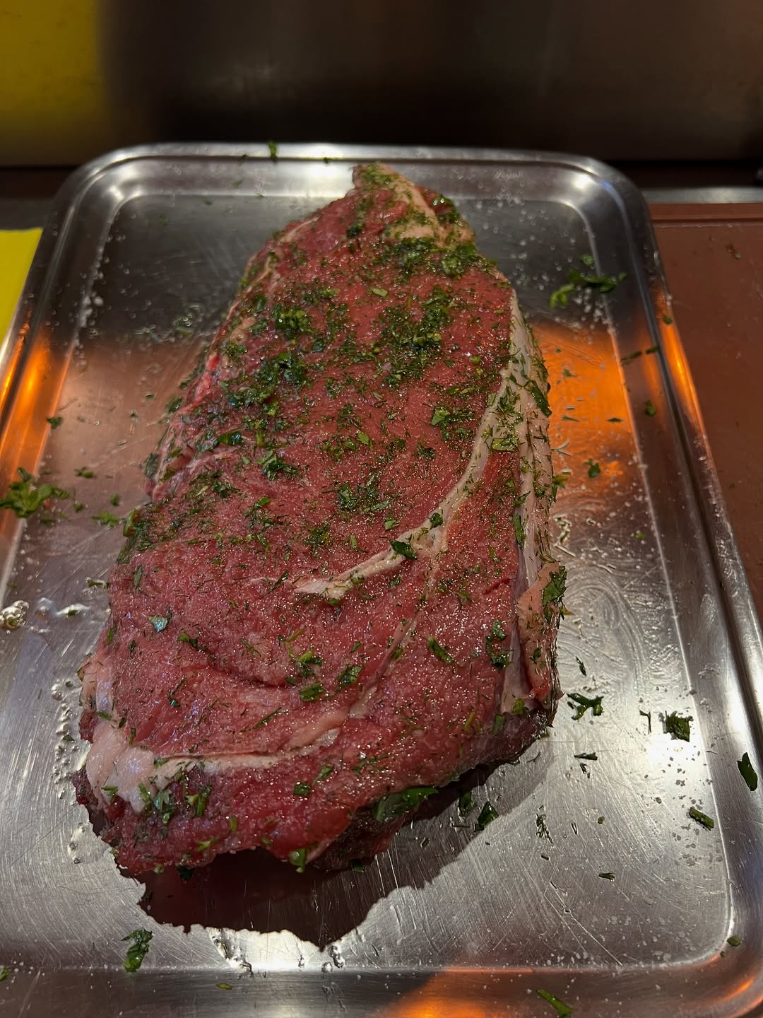 Peça de carne assada sobre tabuleiro metálico