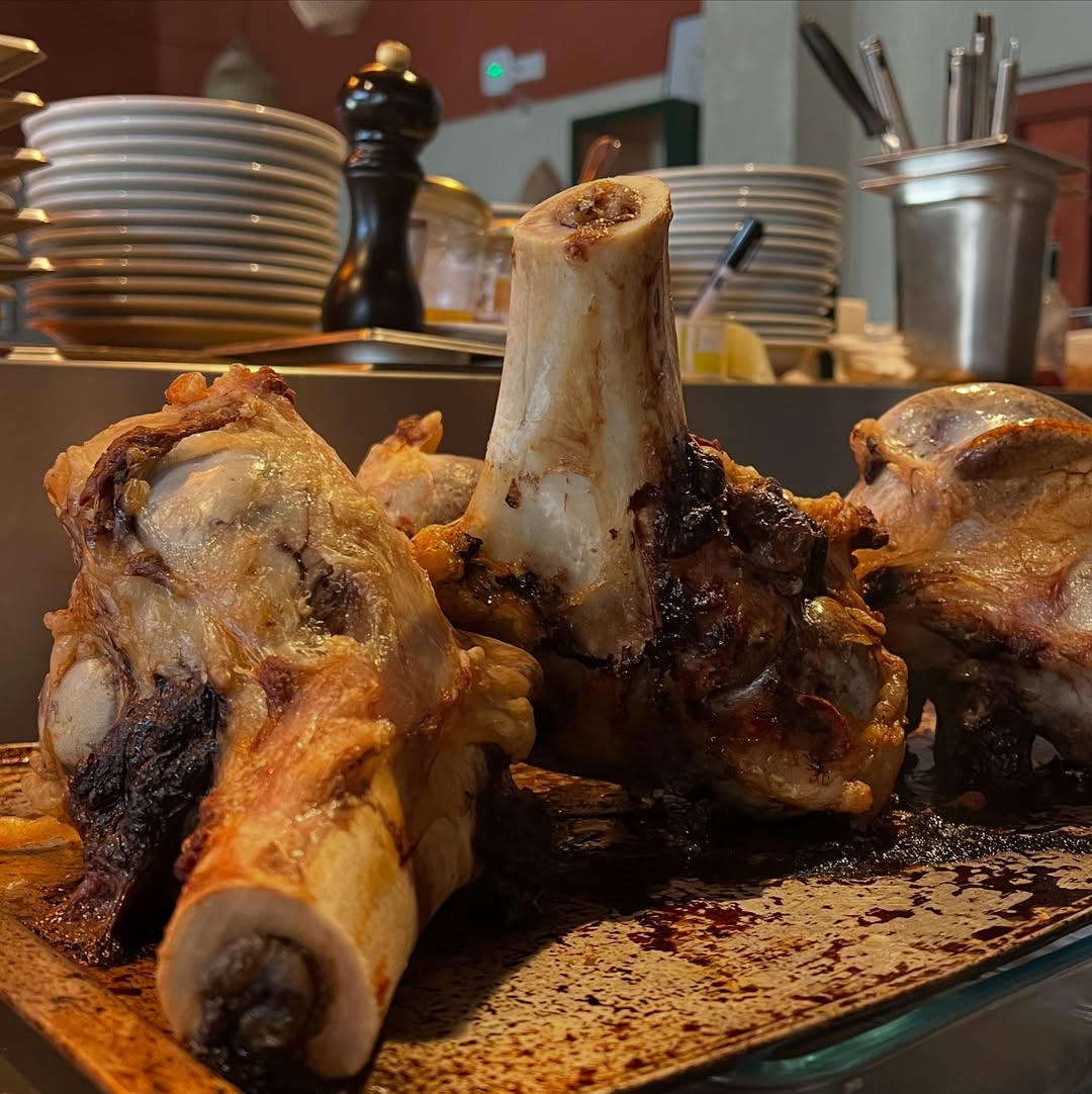 Carne assada com osso, servida numa tábua de madeira